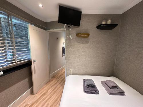 a bedroom with a bed with a tv on the wall at Remarkable 1-Bed Studio in London in London