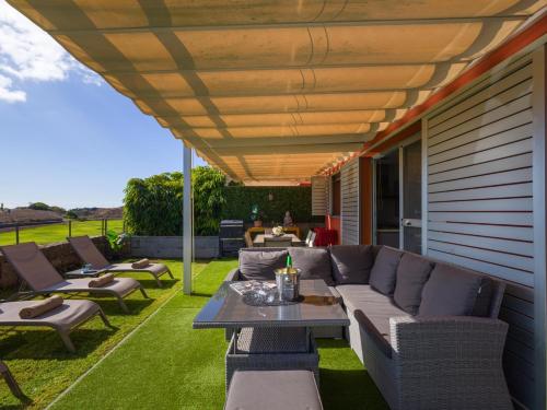 a patio with a couch and chairs and a table at Vista Golf 20 by VillaGranCanaria in Maspalomas