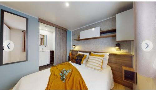 um quarto com uma cama com um cobertor amarelo em Mobil Home -LES Flamants Roses MAR ESTANG em Canet-en-Roussillon