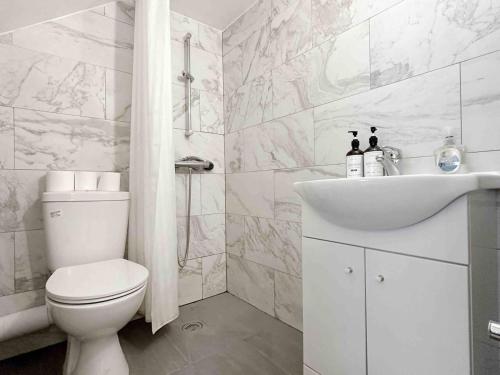 Baño blanco con aseo y lavamanos en Remarkable 1-Bed House in London en Londres