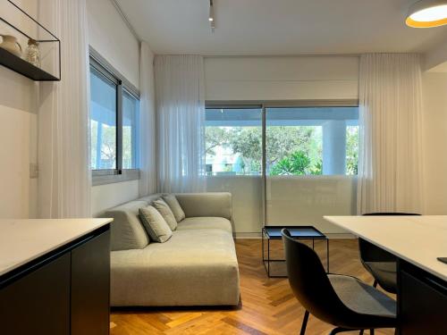 uma sala de estar com um sofá e uma mesa em New apt - 3BD on the boulevard em Tel Aviv