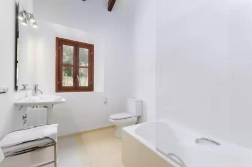 a white bathroom with a sink and a toilet at Puig de Garrafa in Andratx