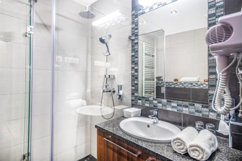 a bathroom with a sink and a shower at Szarvaskút Hotel in Zirc
