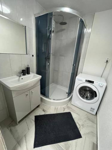 a bathroom with a shower and a washing machine at Apartmán Majka in Snina