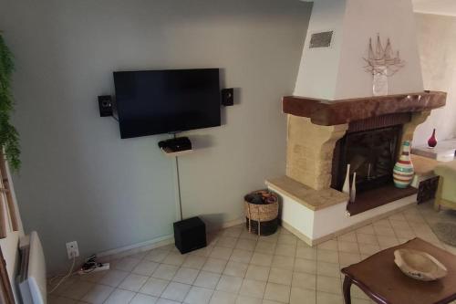 sala de estar con chimenea y TV de pantalla plana en Welcome, Bienvenue, Chez Charly! en Nébian