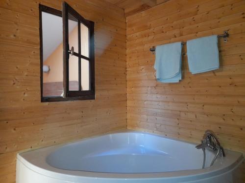 a bath tub in a wooden bathroom with a window at Maison entière avec petite cour intérieure. in Monthureux-sur-Saône