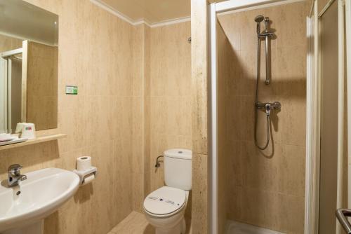 a bathroom with a toilet and a sink and a shower at Hotel Bedoya in Santander