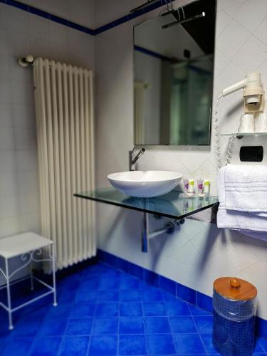 a bathroom with a glass sink and a mirror at Aquazzurra Resort & Aparthotel in Cannobio
