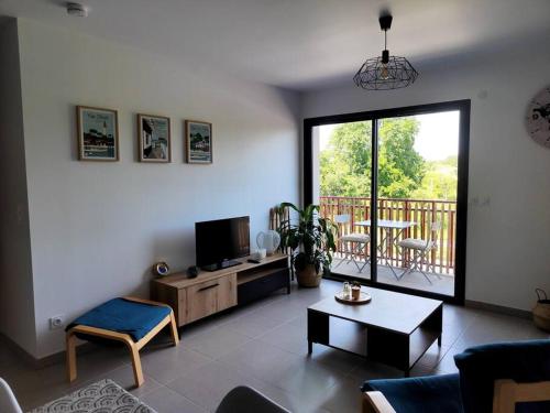 Μια τηλεόραση ή/και κέντρο ψυχαγωγίας στο Location de vacances à Andernos - appartement 2 chambres dans résidence neuve