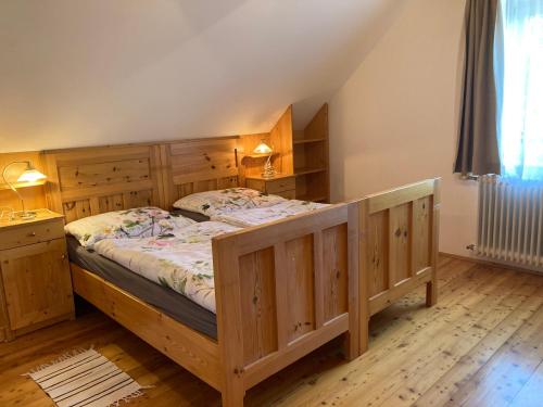 a bedroom with a large wooden bed with wooden cabinets at Althammerhof in Klamm