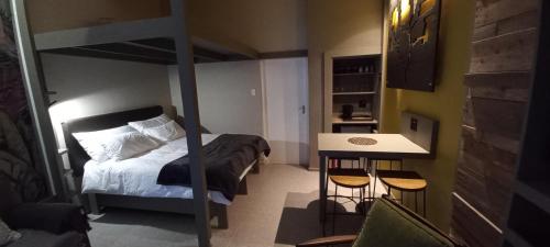 een kleine slaapkamer met een stapelbed en 2 krukken bij Mitford Marula in Morganʼs Bay