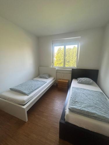 two beds in a room with a window at Montel PARK - Traun in Linz