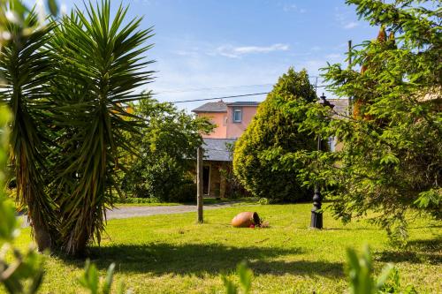 a person sitting in the grass in front of a house at LOW COST CASA BRAIS in San Pedro de Benquerencia