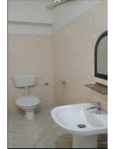 bagno bianco con servizi igienici e lavandino di Hotel Saraswati International, Muzaffarapur a Muzaffarpur