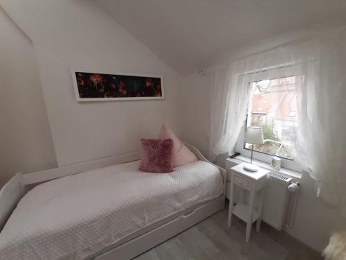 a small bedroom with a bed and a window at Ferienhaus Aschersleben in Aschersleben