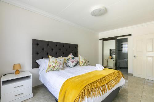 ein Schlafzimmer mit einem großen Bett und einer gelben Decke in der Unterkunft Signature Lodge in Kempton Park