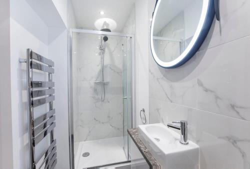 y baño con ducha, lavabo y espejo. en The Haven At The Lawrence Apartments en York