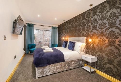 1 dormitorio con 1 cama grande y pared con papel pintado en The Haven At The Lawrence Apartments en York
