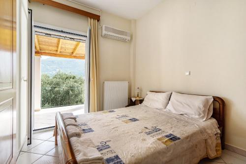 een slaapkamer met een bed en een groot raam bij Daratos apartment 3 in Kefallonia