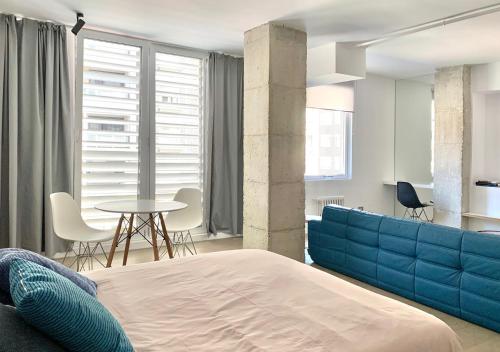 1 dormitorio con 1 cama azul, mesa y sillas en Estudio, en Ponferrada