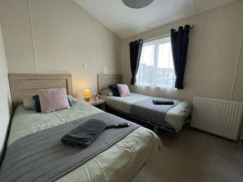 a bedroom with two beds and a window at 2 The Green in Tattershall