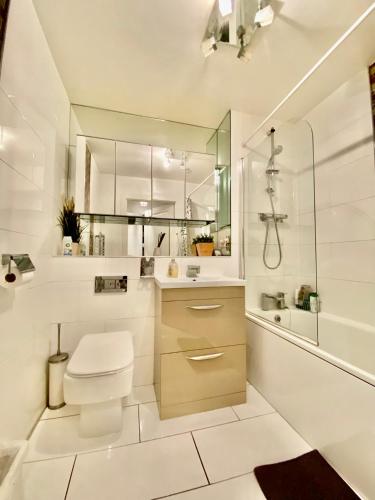 uma casa de banho branca com um WC e um chuveiro em Charmingly cozy 2 beds apartment em Belvedere