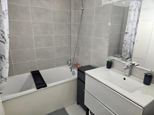 W łazience znajduje się wanna, umywalka i wanna. w obiekcie Cosy appartement près *RER et Disney, Paris w mieście Villiers-sur-Marne