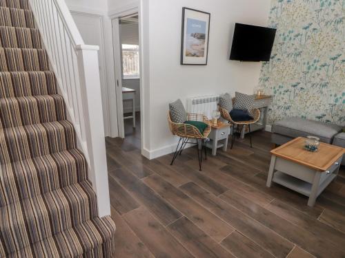 a living room with a staircase and a table and chairs at Gwynfryn in Swansea