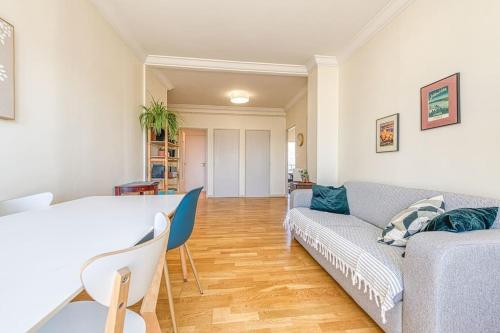 een woonkamer met een bank en een tafel bij Proche Parc Paul Mistral, 2 chambres, wifi, balcon in Grenoble