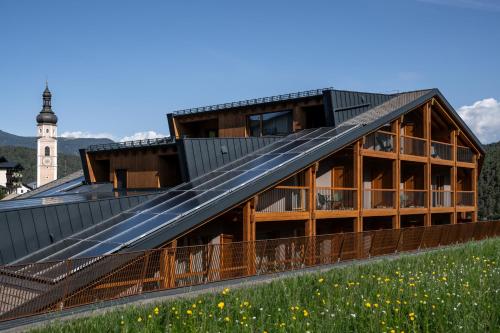a building with solar panels on the roof at Hotel Alpenroyal in Castelrotto