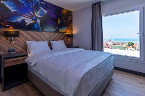 a bedroom with a large bed and a large window at Yusufhan Suites in Trabzon