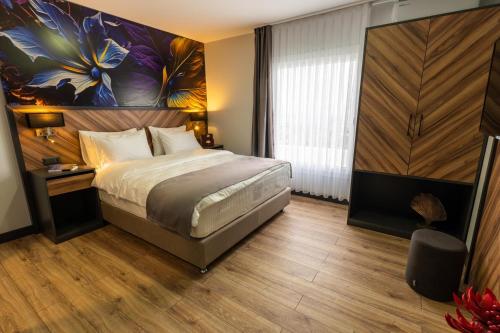 a bedroom with a bed and a painting on the wall at Yusufhan Suites in Trabzon
