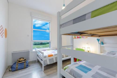 a kids room with two bunk beds and a window at Villa Enora Bretagne Piscine Intérieure Partagée Jacuzzi privatif 100m Plage in Sibiril