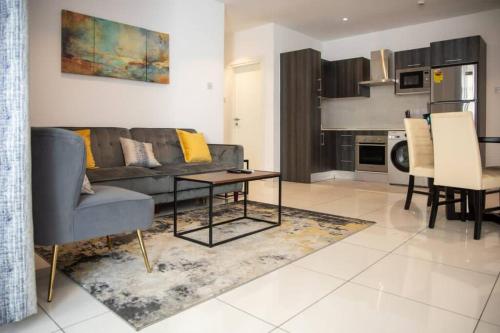 a living room with a couch and a table at Sunshine Large 1Bed + Big Balcony @Embassy Gardens in Cantonments