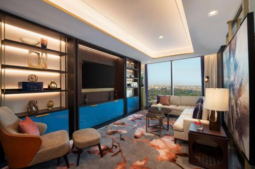 a living room with a couch and a tv at Waldorf Astoria Kuwait in Kuwait