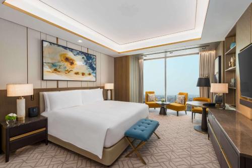 a bedroom with a large bed and a living room at Waldorf Astoria Kuwait in Kuwait