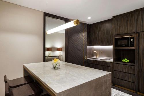 a kitchen with a large counter with a vase of flowers at Waldorf Astoria Kuwait in Kuwait