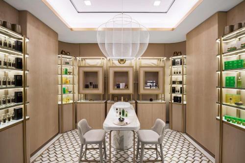 a dressing room with a table and chairs and a chandelier at Waldorf Astoria Kuwait in Kuwait