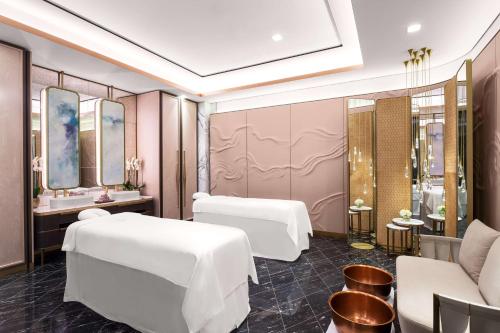 a spa room with two beds and a mirror at Waldorf Astoria Kuwait in Kuwait