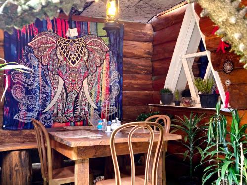 tavolo e sedie in una stanza con arazzo di elefante di Haven chalet a Nuwara Eliya