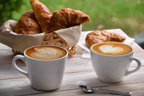 two cups of coffee and a basket of croissants at Crisan B&B Affittacamere in Nola