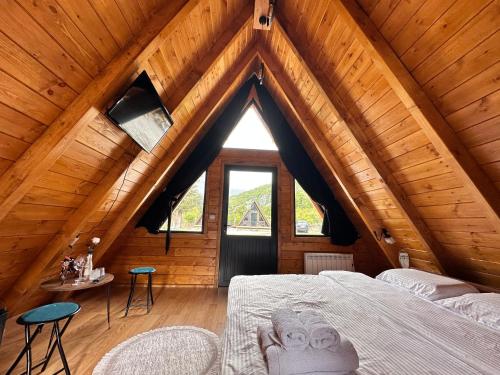 a room with a bed in a wooden attic at Thethi Villas in Theth