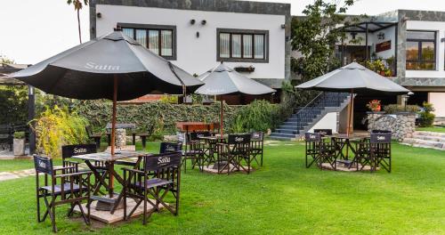 a group of tables and chairs with an umbrella at Hotel Los Sauces in Cafayate