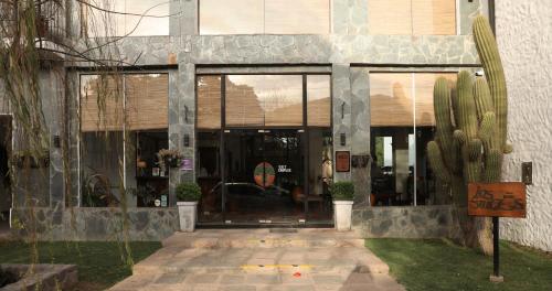 um edifício com grandes portas de vidro e um cacto em Hotel Los Sauces em Cafayate