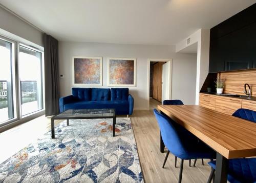 a living room with a blue couch and a table at Poznań Apartments Towarowa in Poznań