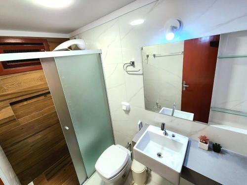 bagno con servizi igienici, lavandino e specchio di 020A - Sobrado de 3 quartos para alugar, Bombinhas/SC a Bombinhas