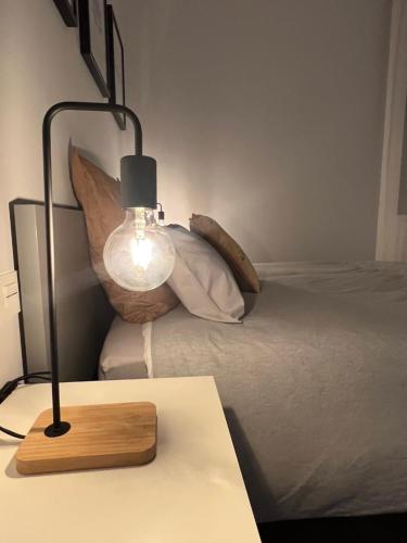 a lamp on a table next to a bed at Loft RioArga. Comodidad y Estiloa a 5 min Centro. Nuevo!!! in Pamplona