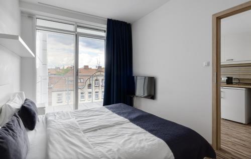 a bedroom with a bed and a large window at Poznań Apartments Towarowa in Poznań
