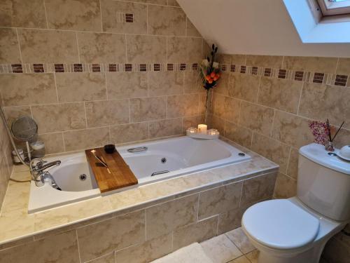 a bathroom with a bath tub and a toilet at Mountain view kingscourt 