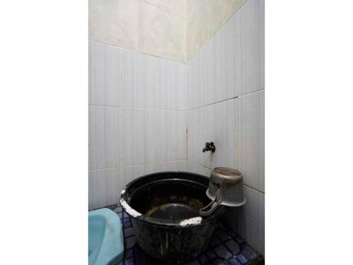 Baño con cubo en la esquina de una habitación en OYO Life 93061 Kost Vicky Syariah en Surabaya